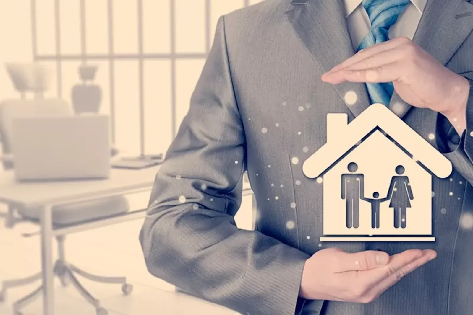 Hombre sosteniendo la figura de una casa con una familia dentro